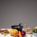 Studio composition of fresh vegetables and a frying pan, ideal for healthy cooking and recipe preparation.