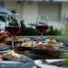 Luxurious outdoor table setting featuring red wine and a variety of gourmet dishes for a sophisticated dining experience.