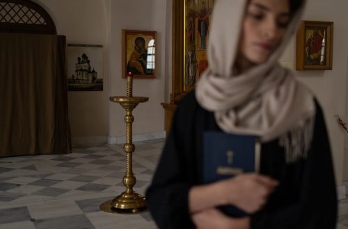 Woman with headscarf holding book in serene church setting, embodying spirituality.