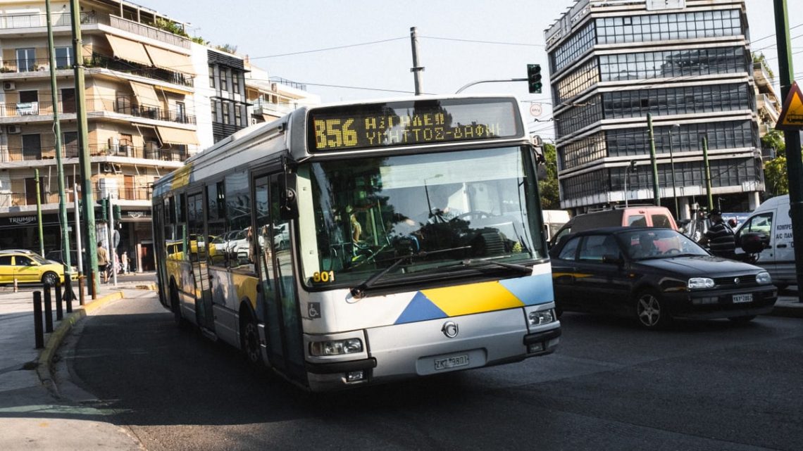 Cityscape of Athens featuring a public bus on a bustling street, capturing urban life.